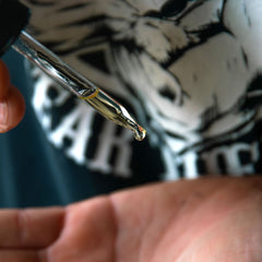 Photo of Badass Beard Oil being dropped into a mans hand before application